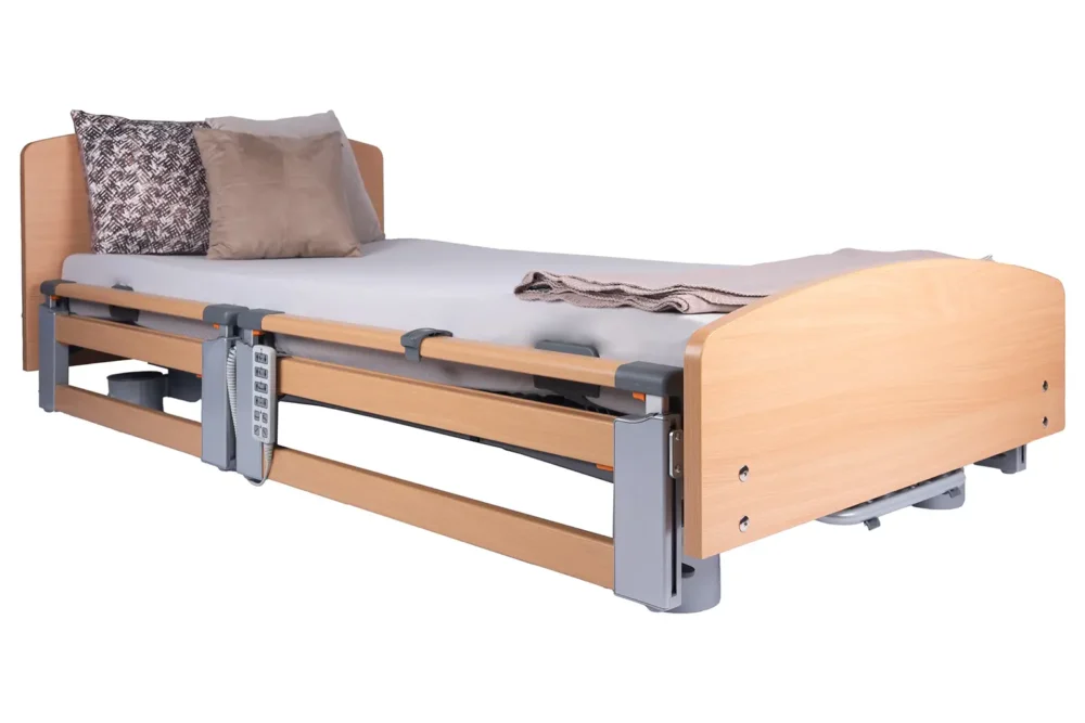 Adjustable wooden hospital bed with side rails, headboard, and attached remote control on the rail.
